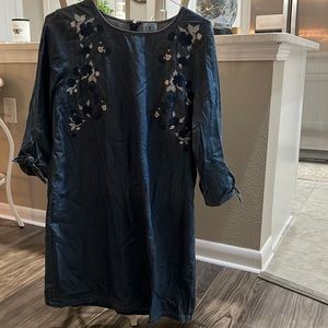 Denim dress with embroidered highlights and rounded neckline.